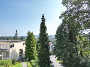 Ausblick Service Wohnen Blick von der Pflegeeinrichtung über Bäume, Häuser und die hügelige Landschaft von Neviges bei Sonnenschein.